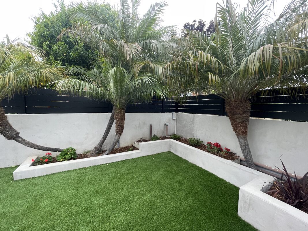 Modern black wall topper enhancing greenery and landscaping in a Ventura outdoor space.