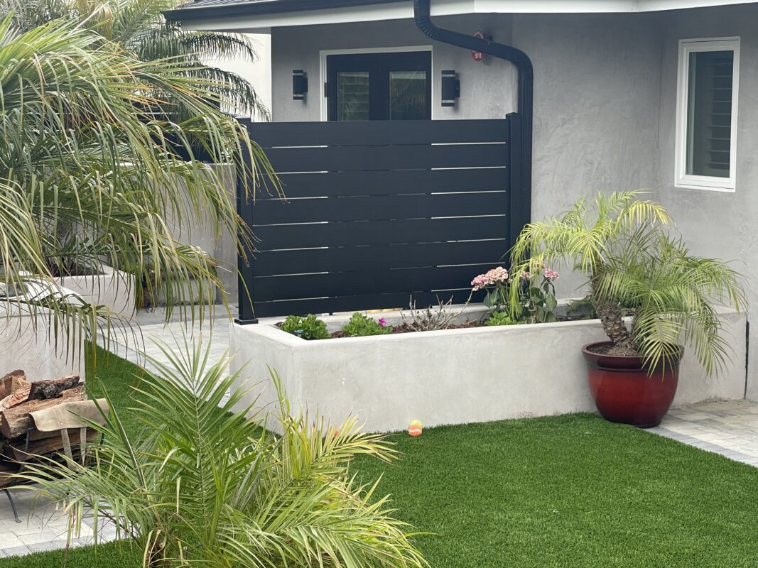 Modern black wall topper enhances privacy and style in a Ventura coastal setting.