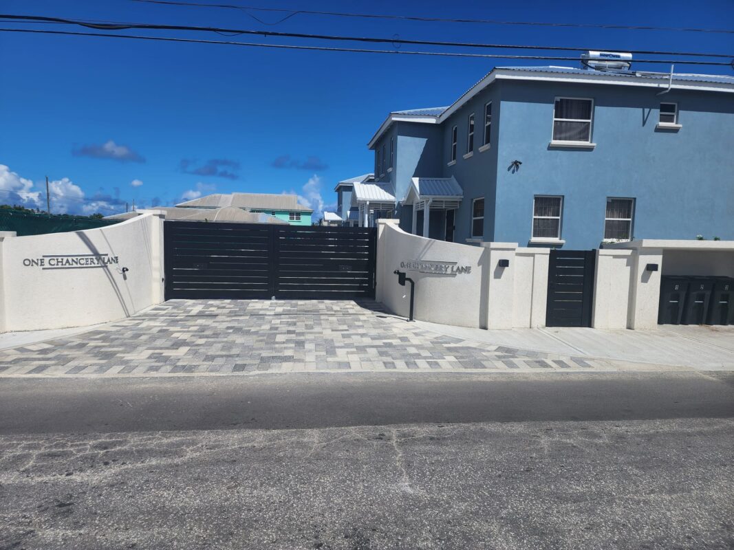 Elegant black double swing gate at a modern home entrance in St. James, Barbados.