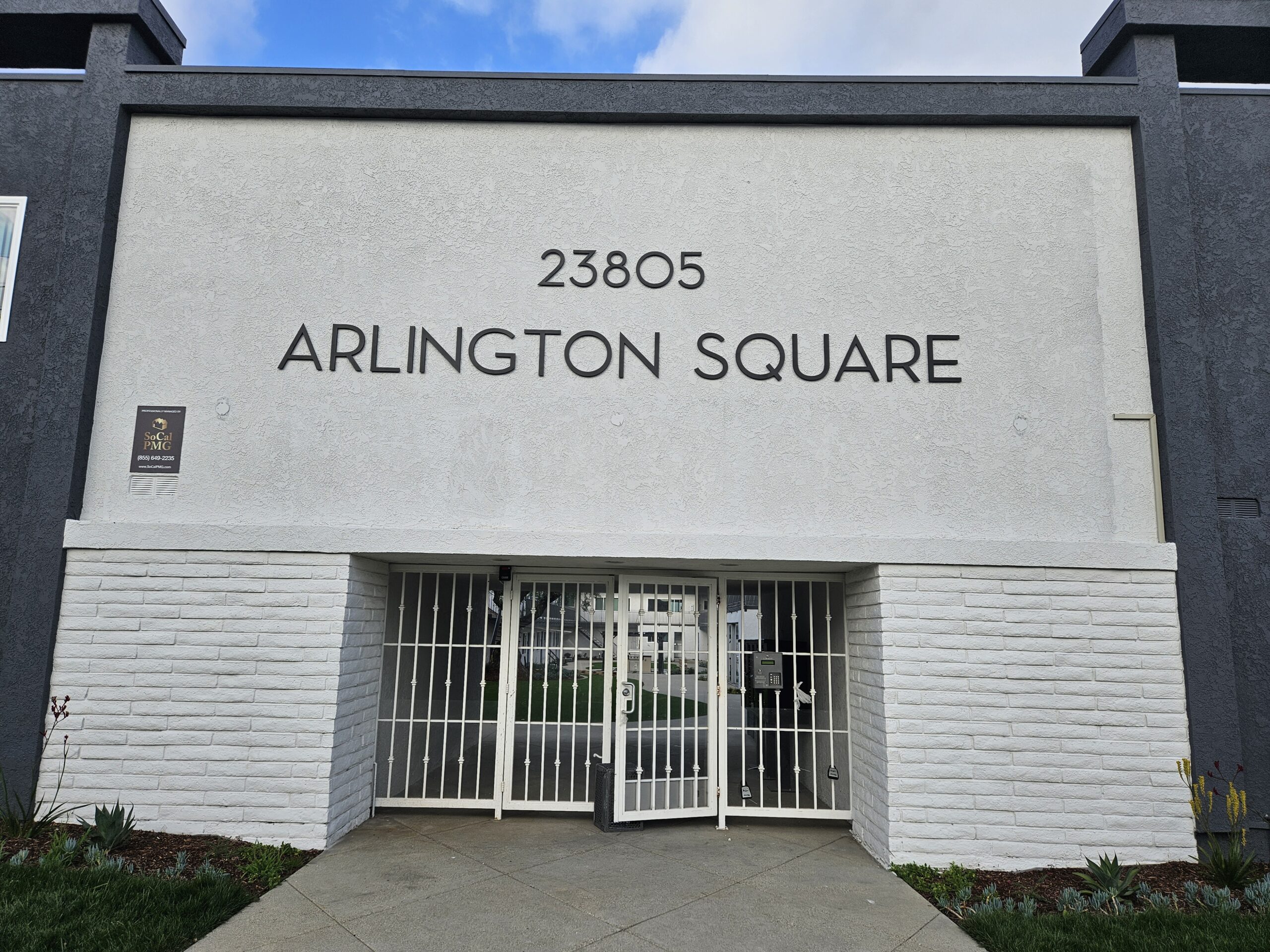 Front view of a building with a gated entrance and large signage above the door.