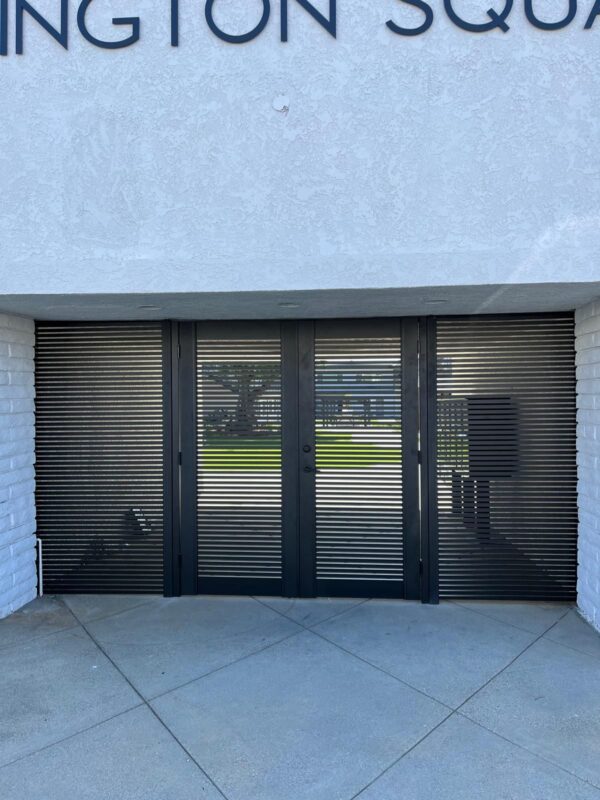 Black aluminum gate installed at a commercial property entrance with modern design.