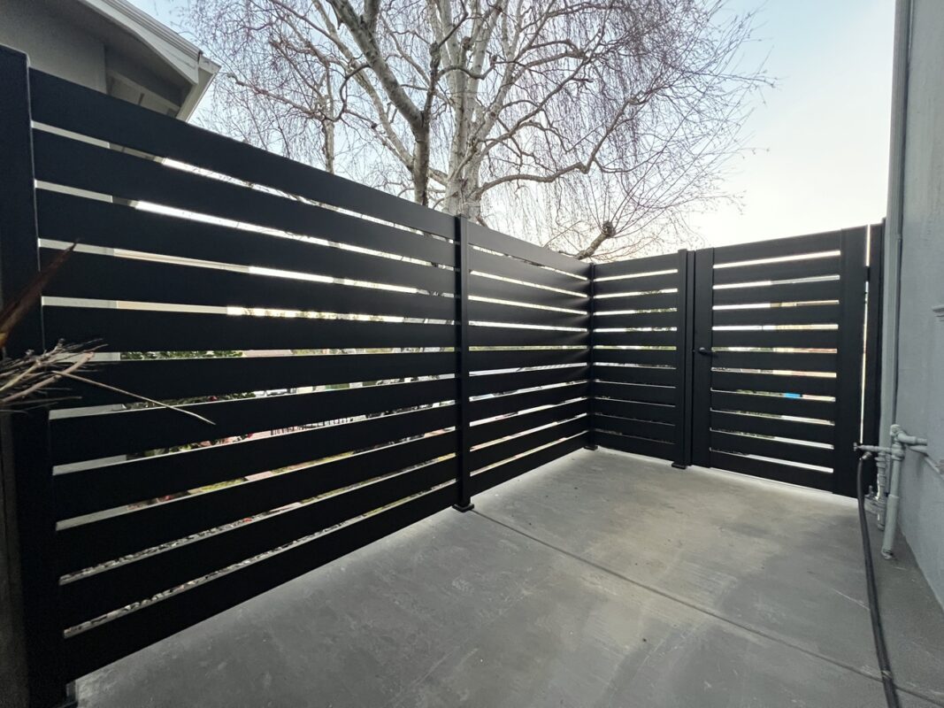 Sleek black LA style fence installation with horizontal slats in a modern outdoor space.