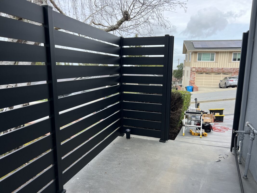 Sleek black fence installation with tools visible, enhancing property aesthetics in the Bay Area.